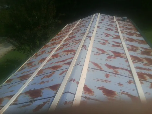 Rusted metal roof panels with new wood purlins before replacement — Storm Damage Roof Repair in Slinger by Roofing Brothers