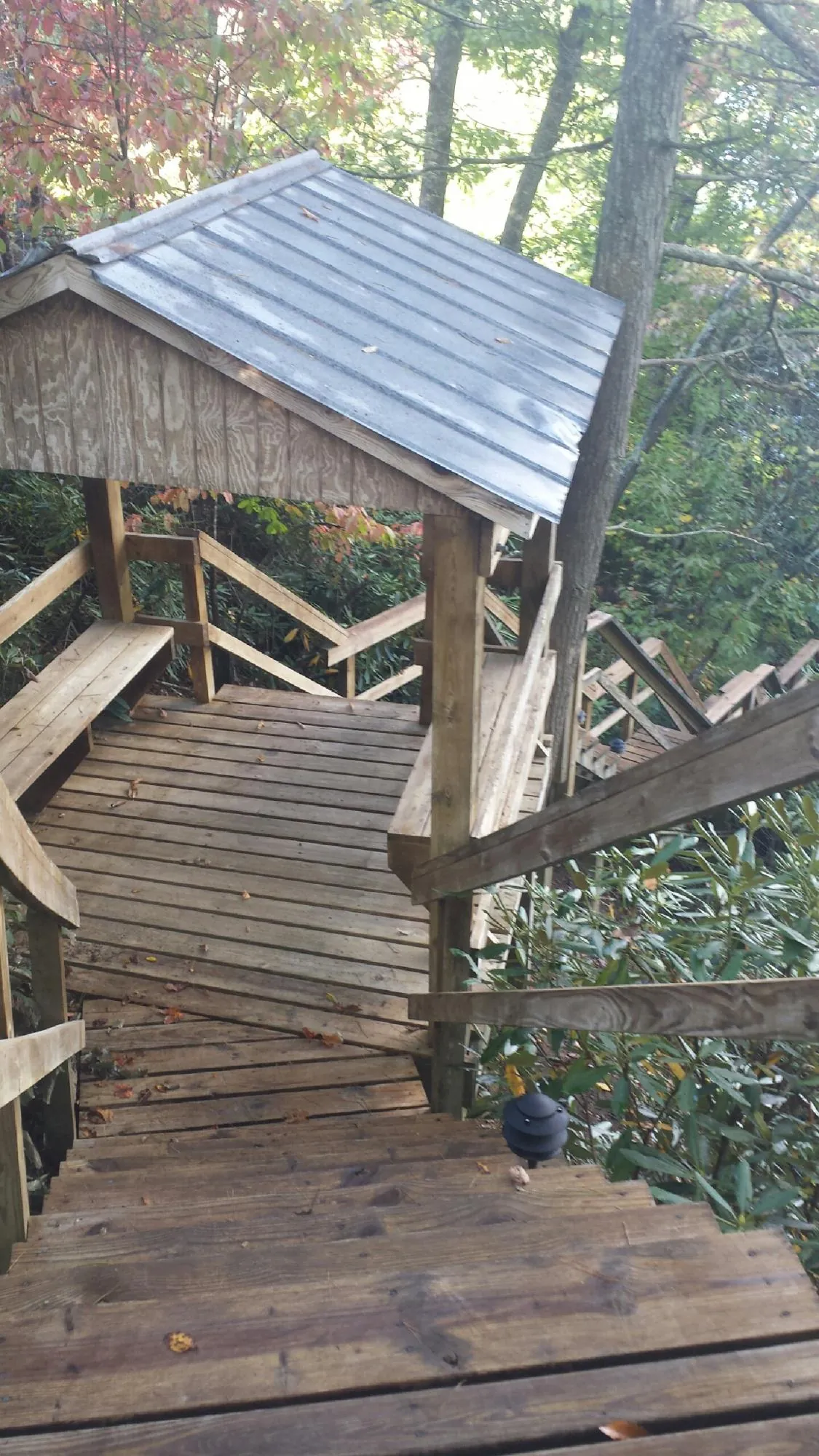 Metal roofed shelter over wooden steps on a wooded walkway — Skylight Repair & Installation work by our crew in Slinger