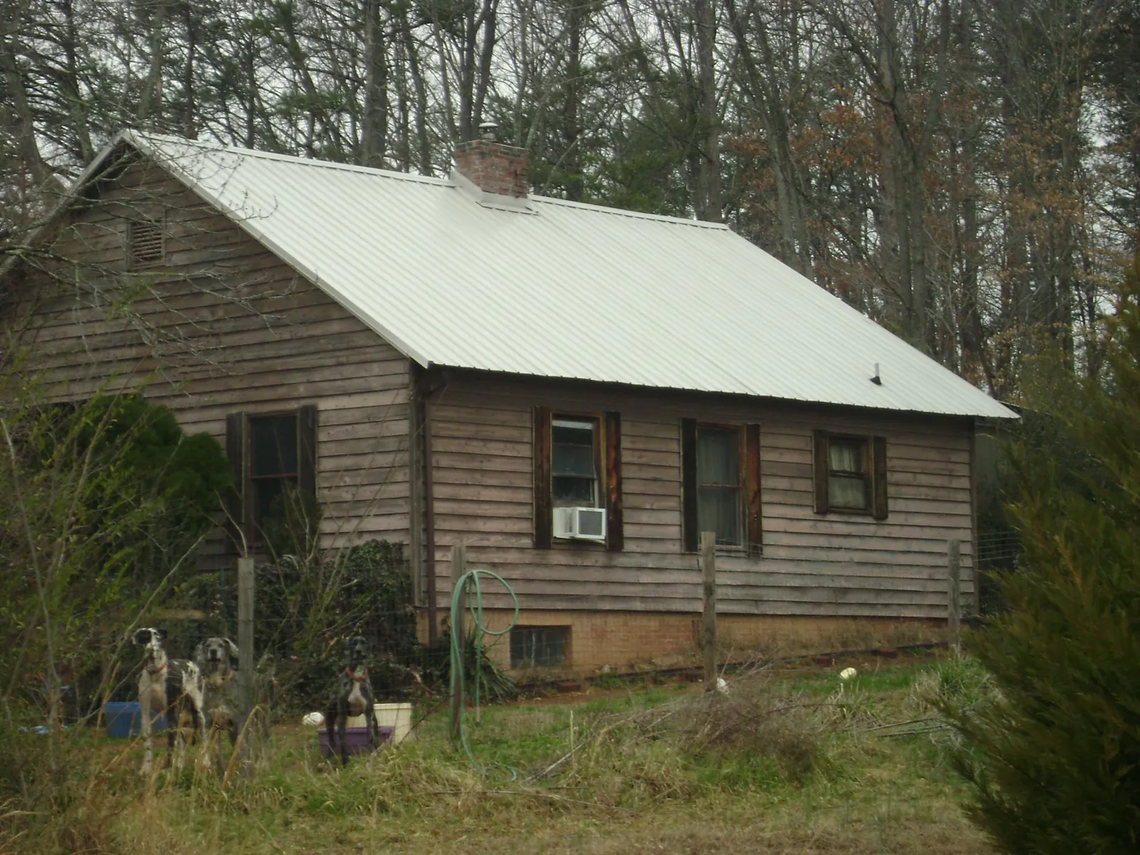White metal roof on an old wood sided farmhouse, from a Metal Roof Installation job in Slinger
